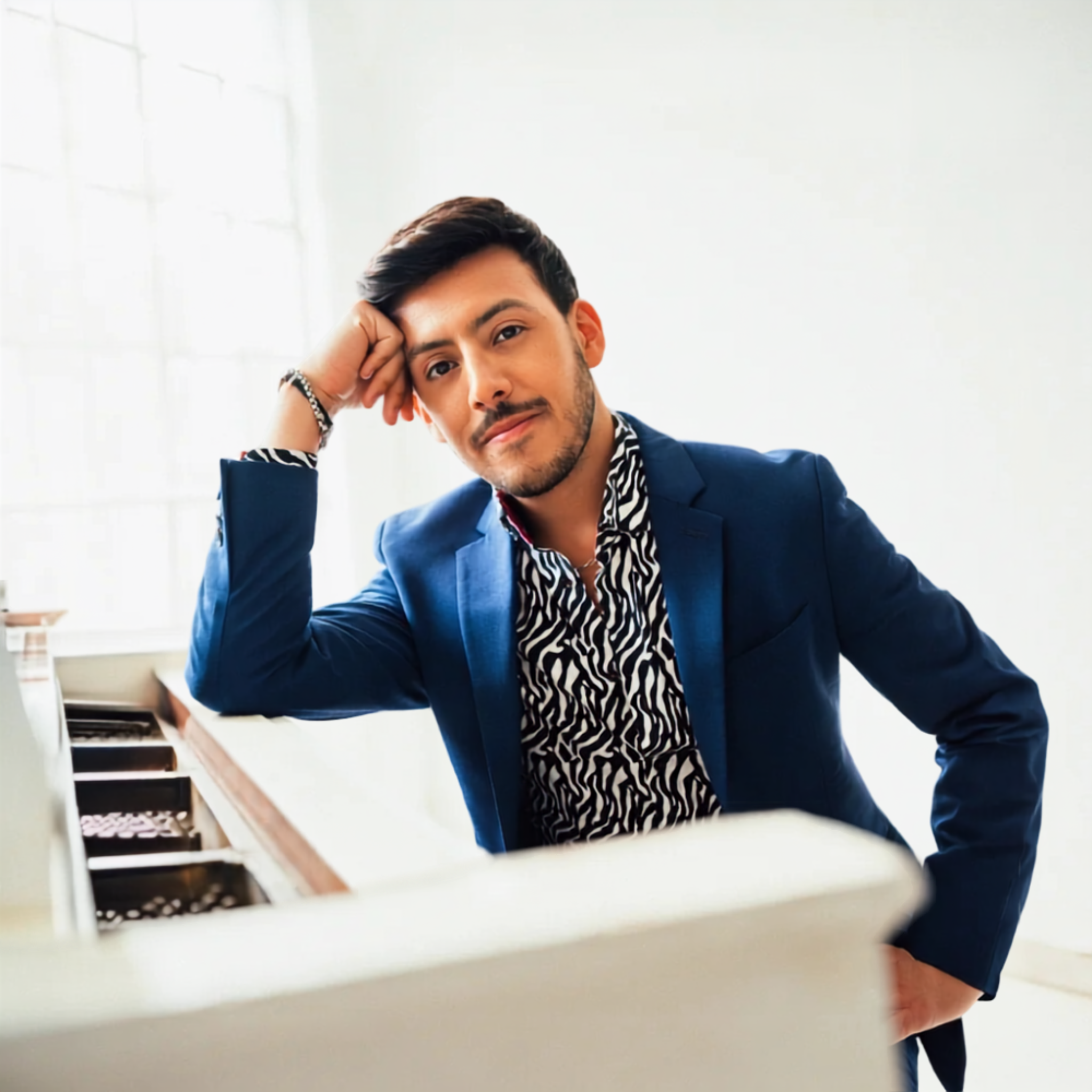 Ben Chavez seated at a white piano